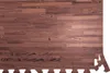A close-up, top-down view of interlocking foam floor mats with a dark wood grain pattern. Náhľad obrázku produktu