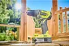 A Ryobi cordless drill is shown in an outdoor setting, possibly during a construction or DIY project. Produktbild-Vorschau