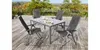 A garden table and chairs set on a wooden deck outdoors. Produktbild-Vorschau