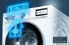 A close-up, angled view of a white Siemens washing machine with digital interface and glowing blue neon graphics overlayed. Produktbild-Vorschau