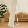 A full-length mirror stands in a room with a plant and a wooden cabinet. Náhľad obrázku produktu