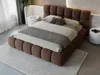 A bedroom scene with a large upholstered bed as the focal point. Produktbild-Vorschau