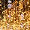 A street decorated with numerous strings of warm white and white LED lights, with spherical light ornaments hanging down. Podgląd zdjęcia produktu