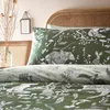 A close-up view of a bed with green bedding featuring a forest animal print. Voir les images du produit