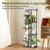 A multi-tier wooden plant stand filled with various plants and decorative items, placed indoors near a window with sheer curtains. A wooden cabinet is visible to the right. Produktbild-Vorschau