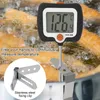 A digital thermometer is shown measuring the temperature of frying food in a pot, with a close-up inset of a stainless steel fixing clip. Produktbild-Vorschau