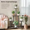 A plant stand with multiple plants is placed next to a sofa in a living room. Náhľad obrázku produktu