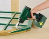 A person is using a cordless heat gun to remove old paint from a wooden window frame. Produktbild-Vorschau