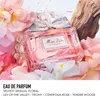 A bottle of Miss Dior perfume surrounded by pink flowers and a piece of driftwood. Podgląd zdjęcia produktu