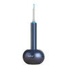 A dark blue ear cleaning device with a camera and light is placed in its charging base. Produktbild-Vorschau
