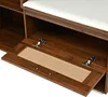 A close-up view of an open storage compartment in a wooden furniture piece, showing hinges and a cane-like insert. Produktbild-Vorschau