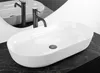 A white oval countertop sink with a dark faucet is shown on a black marble countertop. Produktbild-Vorschau