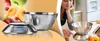 A woman is looking at a digital kitchen scale with a stainless steel bowl on it, with fruits falling around it. Produktbild-Vorschau
