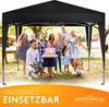 A group of people, including adults and children, are gathered under a black canopy tent, celebrating what appears to be a birthday with a cake. Produktbild-Vorschau