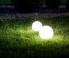 Two glowing white spheres are placed on a grassy lawn at night. Produktbild-Vorschau