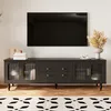 A black TV stand with gold accents is shown in a living room setting, with a television mounted on the wall above it. Anteprima dell’immagine prodotto