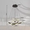A modern chandelier with multiple rings, suspended from a ceiling mount. Produktbild-Vorschau