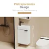 A compact white bathroom vanity with a black faucet is shown mounted on a light beige wall, next to a toilet. Dimensions are indicated with lines and numbers. Náhled obrázku produktu