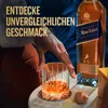 A person's hand reaches for a glass of Johnnie Walker Blue Label whisky next to the bottle. Produktbild-Vorschau