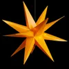 A bright orange, multi-pointed star-shaped lamp is suspended against a black background. Produktbild-Vorschau