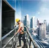 A construction worker on a high-rise building platform is using a cordless drill. Voir les images du produit