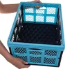 Hands holding a blue and black folding storage box. Produktbild-Vorschau