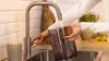 A person is holding a black water tank under a faucet in a kitchen sink. Anteprima dell’immagine prodotto