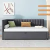 A dark gray upholstered daybed with a pull-out trundle bed, shown with decorative pillows and a piece of abstract art on a light blue wall. Produktbild-Vorschau