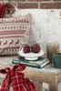 A festive Christmas display on a wooden surface with snow, featuring a glass tree-shaped container with red ornaments inside, a book, and decorative elements. Anteprima dell’immagine prodotto