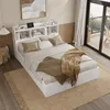 A bedroom scene featuring a white bed with a headboard shelf, bedside tables, and a rug. Produktbild-Vorschau
