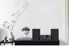 A stereo system is displayed on a dark blue cabinet, next to decorative items like a vase with branches and a bust. Anteprima dell’immagine prodotto