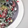 A close-up view of a Christmas tree skirt with wrapped presents and ornaments. Produktbild-Vorschau