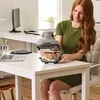 A woman is sitting at a desk with a Ninja CRISPi air fryer and a glass dish of food. Anteprima dell’immagine prodotto