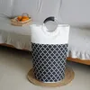 A laundry basket sits on a woven mat in front of a couch. Produktbild-Vorschau