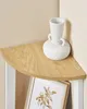A white textured vase sits on a light wood corner shelf. Náhled obrázku produktu