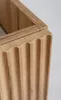 Close-up view of the fluted wooden front of a cabinet, showing the texture and detail of the wood. Produktbild-Vorschau