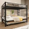 A black metal bunk bed with a pull-out trundle bed is shown in a room with two framed pictures on the wall. Produktbild-Vorschau