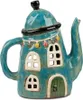 A decorative ceramic teapot shaped like a house, with windows and a door, and adorned with festive lights. Produktbild-Vorschau