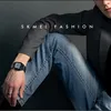 A man wearing a watch and jeans, sitting down. Náhled obrázku produktu