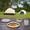 Food and marshmallows on a table in front of tents. Produktbild-Vorschau