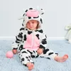 A baby wearing a cow costume sits on a blue carpet. Produktbild-Vorschau