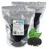 Two sealed plastic bags filled with activated carbon granules, with a label on the front bag and a pile of granules in the foreground. Produktbild-Vorschau