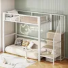 A loft bed with a sofa underneath, a small table, and stairs with shelves, set in a room with a striped green wall. Anteprima dell’immagine prodotto