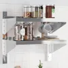 A stainless steel wall shelf with two levels, holding jars, cups, and plates. Anteprima dell’immagine prodotto