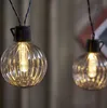 Close-up of two illuminated string lights with ribbed glass bulbs. Podgląd zdjęcia produktu