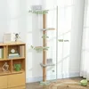 A tall, multi-tiered cat tree with scratching posts and platforms is shown standing against a white wall, next to a wooden bookshelf. Náhled obrázku produktu