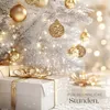A festive Christmas scene with a white, frosted tree decorated with gold ornaments and lights, and several wrapped gifts in the foreground. Náhled obrázku produktu