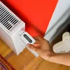A hand is adjusting a smart thermostat on a radiator. Náhľad obrázku produktu
