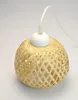 A close-up studio shot of a pendant light with a woven bamboo shade and a white top cap. Produktbild-Vorschau