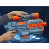 A person's hands are holding a Nerf Elite 2.0 Phoenix CS-6 blaster with a scope attached. The background is a dark blue grid with glowing blue circles. Podgląd zdjęcia produktu